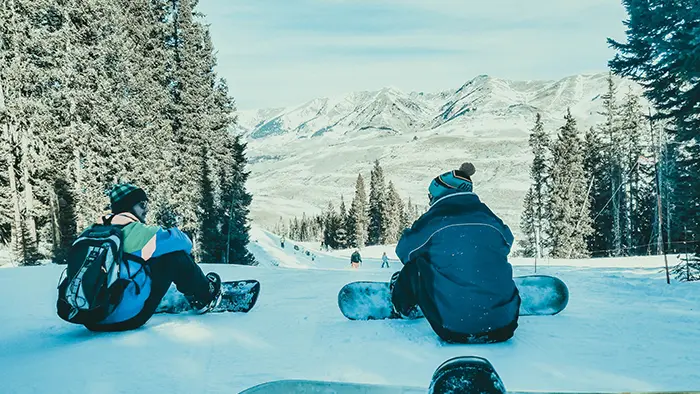 Snowboarder se pogovarjajo o boardanju v šoli bordanja,